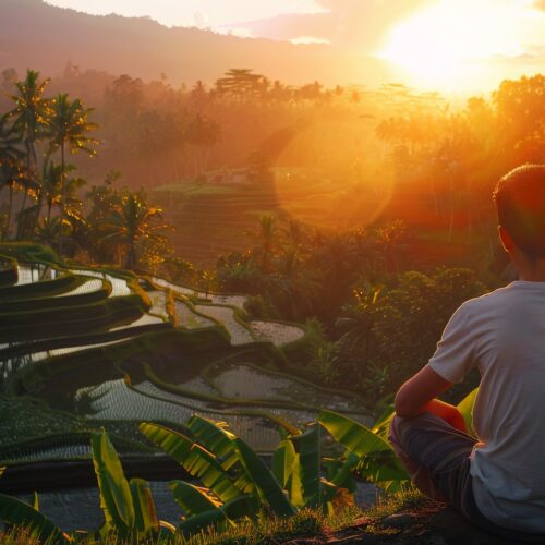 A man in a reflective moment watching sunrise over the rice terraces in Bali