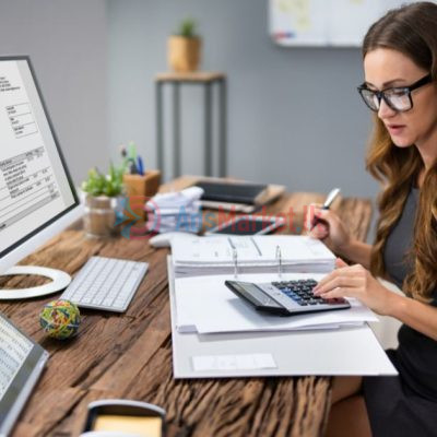 woman-bookkeeper-working-at-her-desk-with-a-calculator-and-computer